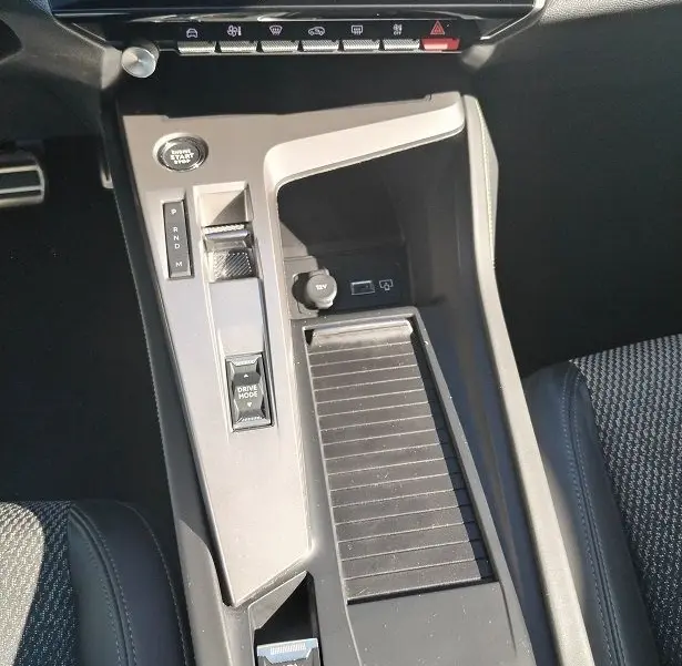 Vue rapprochée de la console centrale intérieure de la Peugeot 308 SW Hybrid 145 GT avec commandes de boîte auto et écran tactile.