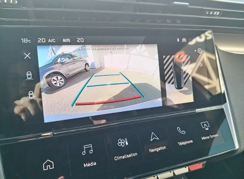 Écran intérieur de la Peugeot 308 SW Hybrid 145 GT montrant la caméra de recul avec guidage de trajectoire.