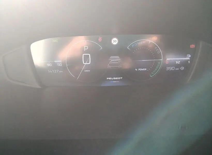 Tableau de bord numérique du Peugeot 308 SW Hybrid 145 GT, affichant vitesse, autonomie et indicateurs d'énergie.