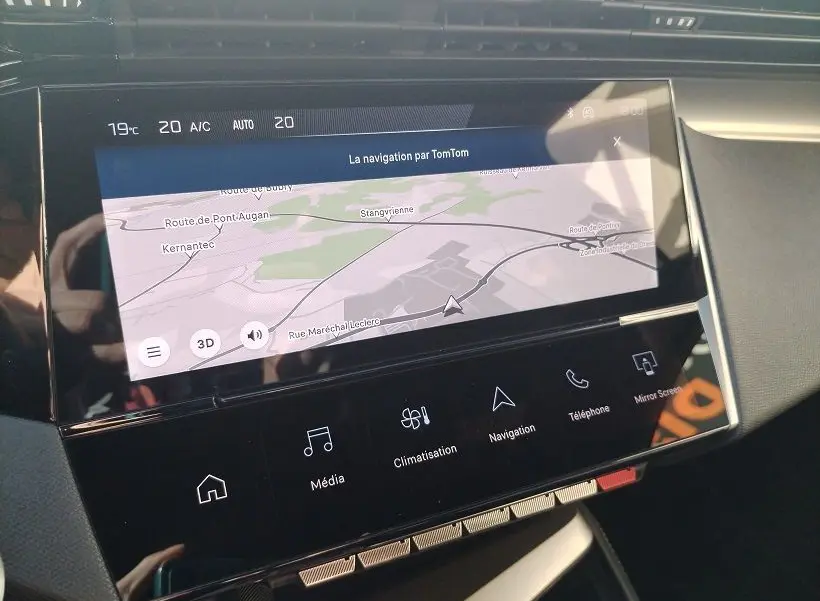 Écran tactile central de la Peugeot 308 SW Hybrid 145 GT montrant la navigation TomTom avec commandes tactiles en bas.