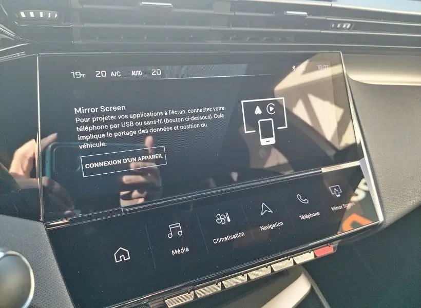 Écran tactile central de la Peugeot 308 SW Hybrid 145 GT 2025, affichant les options Mirror Screen et climatisation.