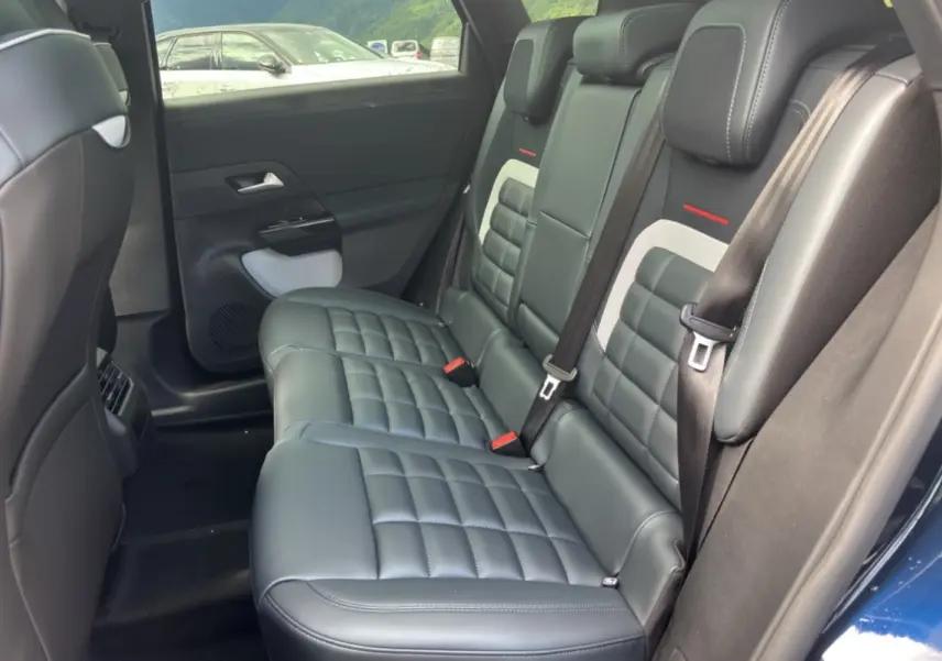 Vue intérieure côté droit sur la banquette arrière cuir noir matelassé du Citroën C5 Aircross New Hybrid 2026 bleu eclipse.