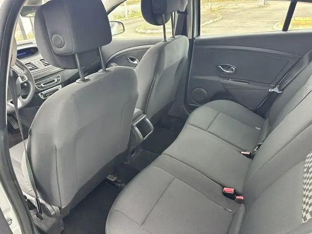Vue intérieure arrière côté droit de la Renault Megane 3 gris, montrant les sièges arrière et partie avant du véhicule.
