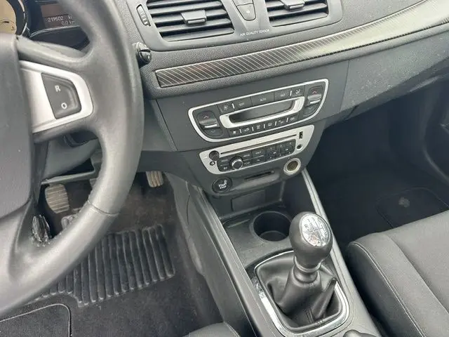 Vue intérieure centrée sur la console centrale et levier de vitesse manuel d'une Renault Mégane 3 grise de 2012.