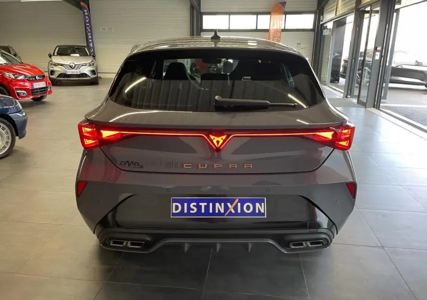 Vue arrière d'une CUPRA Leon gris Graphène avec feux arrière Tri-LED et double sortie d'échappement noire.