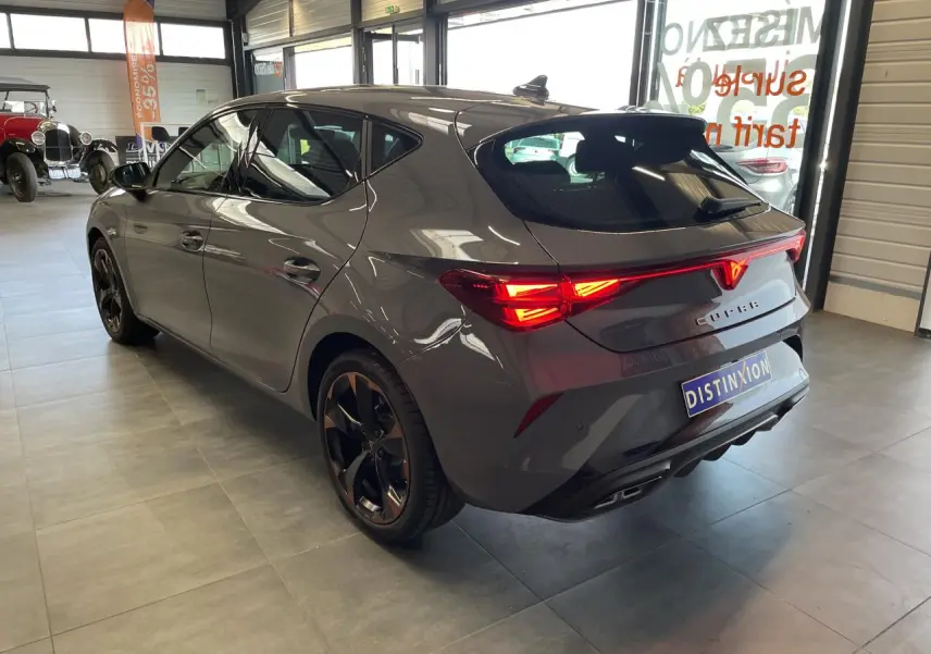 Vue 3/4 arrière droite d'une CUPRA Leon gris Graphène avec feux arrière Tri-LED et jantes alliage 18'' cuivrées.