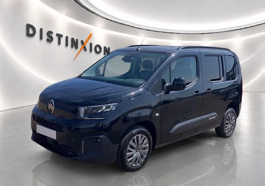 Vue 3/4 avant droit d'un Citroën Berlingo noir 2026 avec barres de toit et jantes alu visibles.