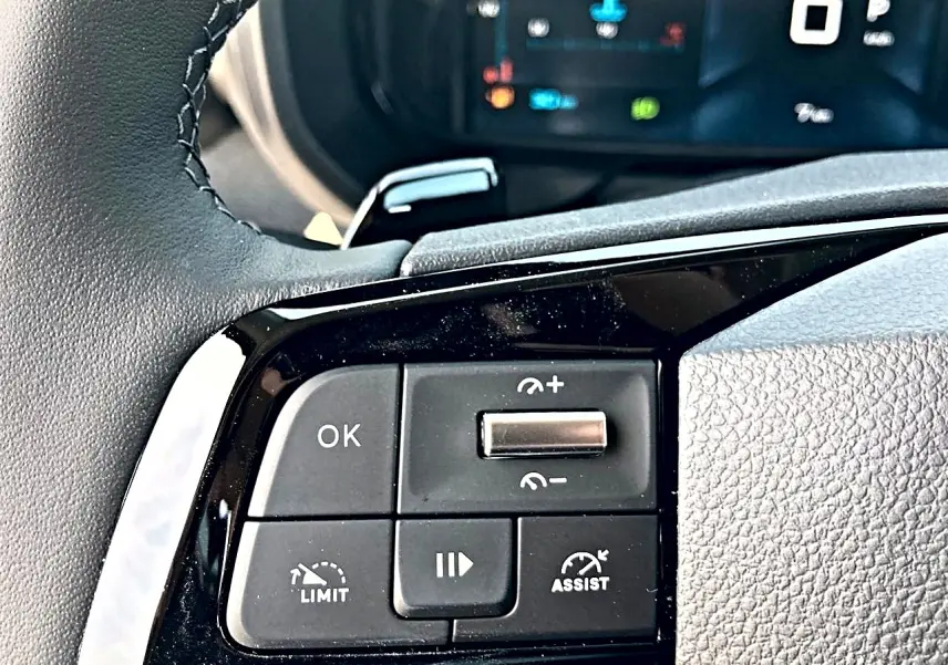Gros plan sur les commandes au volant noir du Citroën Berlingo N1, avec boutons multifonctions et finition brillante.