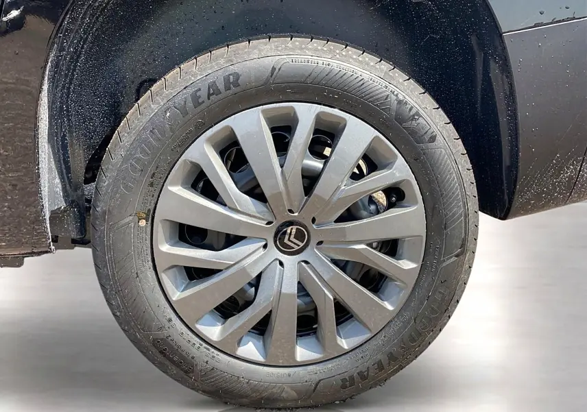 Gros plan sur la roue avant gauche noire d’un Citroën Berlingo N1 avec jante alu et logo Citroën central.