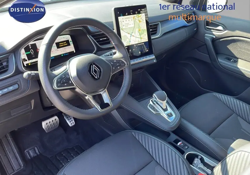 Intérieur moderne du Renault Captur E-Tech 2025, vue du poste de conduite avec écran tactile vertical et sellerie noire.