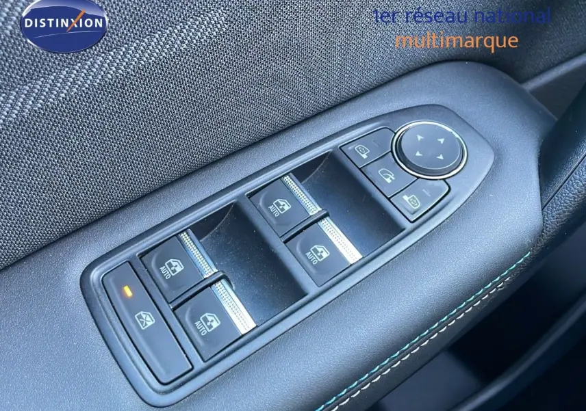 Gros plan sur les commandes des vitres électriques côté conducteur d'un Renault Captur bleu Iron Metal toit noir 2025.