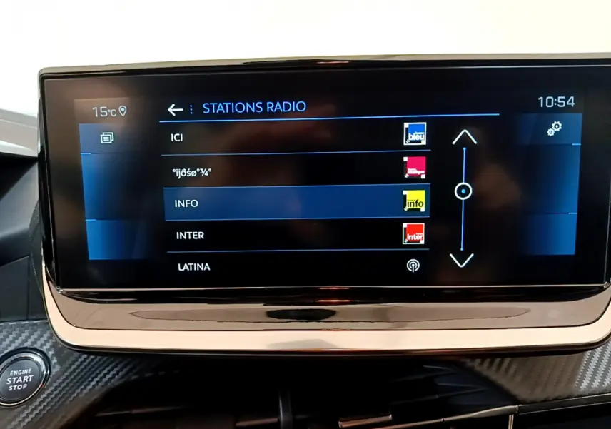 Écran tactile central affichant les stations radio dans l'habitacle d'une Peugeot 208 gris foncé de 2022.