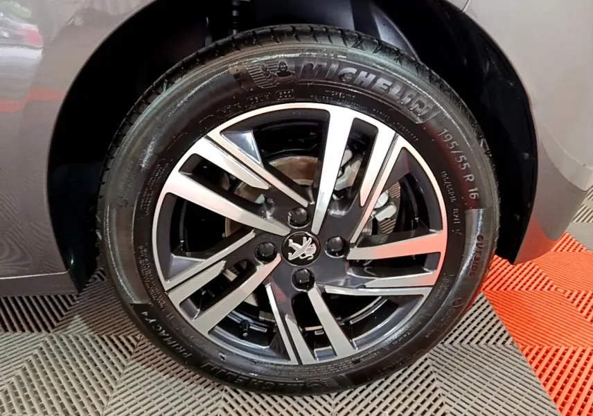 Gros plan sur la roue avant droite gris foncé d'une Peugeot 208 2022 avec jante alliage et pneu Michelin.