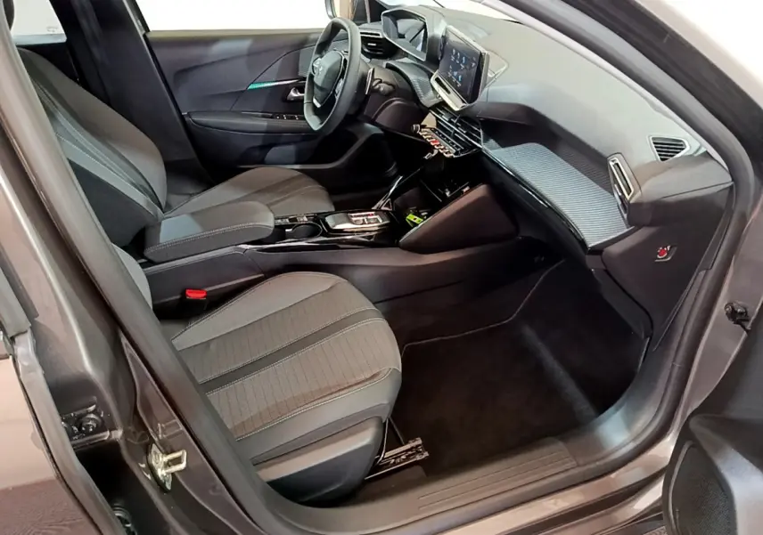 Intérieur côté conducteur de la Peugeot 208 gris foncé 2022, avec tableau de bord moderne et écran tactile central.