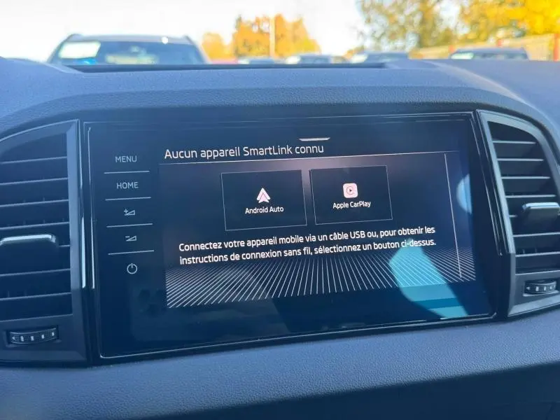 Écran tactile central du Skoda Karoq gris 2025 affichant les options Android Auto et Apple CarPlay, vue intérieure frontale.