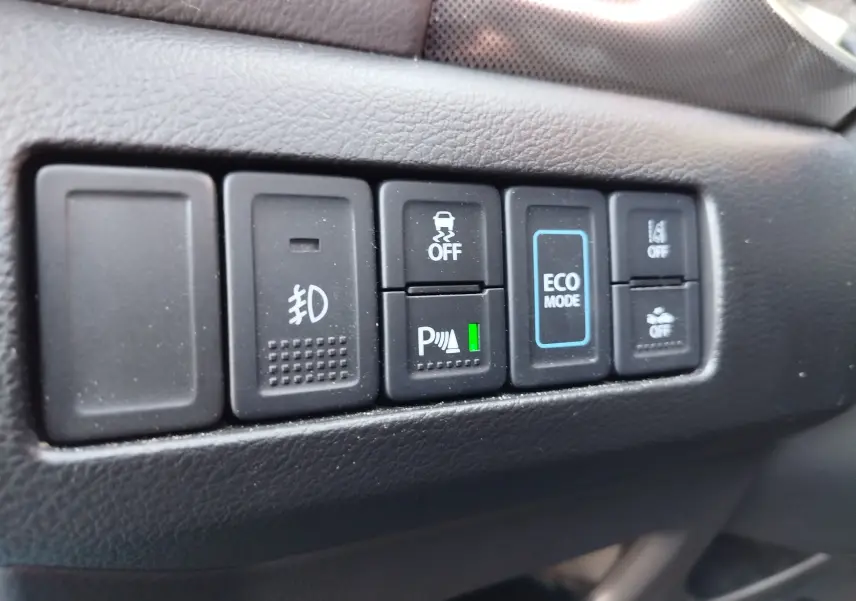 Gros plan sur les boutons de commande intérieurs du Suzuki Vitara hybride, avec le bouton Eco Mode bien visible.