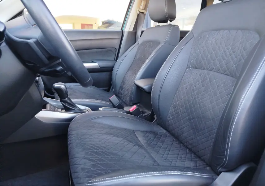 Vue intérieure côté gauche du Suzuki Vitara 2023, montrant les sièges avant en cuir et alcantara noir avec surpiqûres blanches.