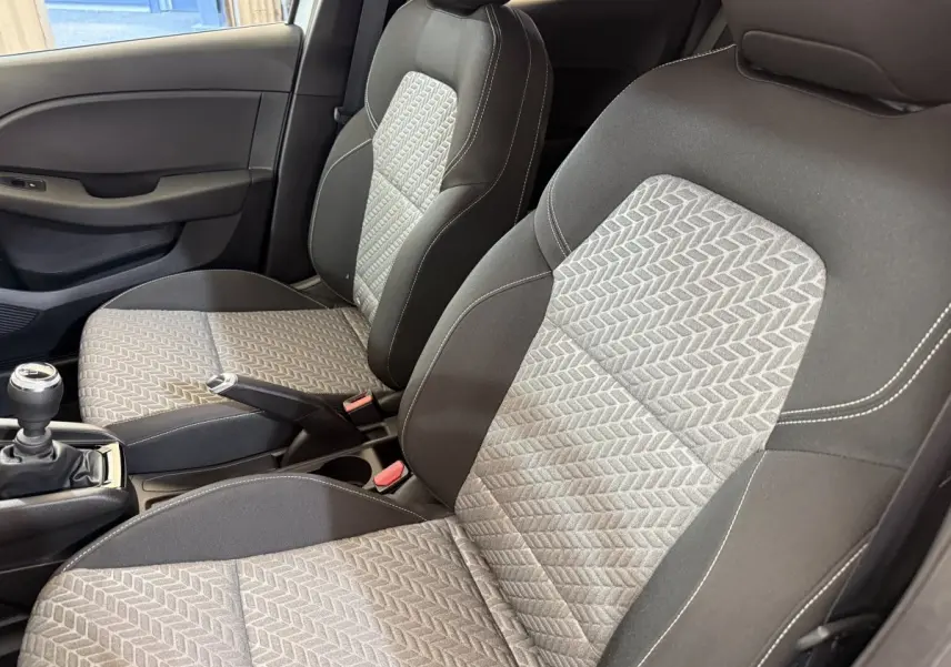 Vue intérieure rapprochée des sièges avant gris clair et foncé avec motifs géométriques de la Renault Clio Business 2023.