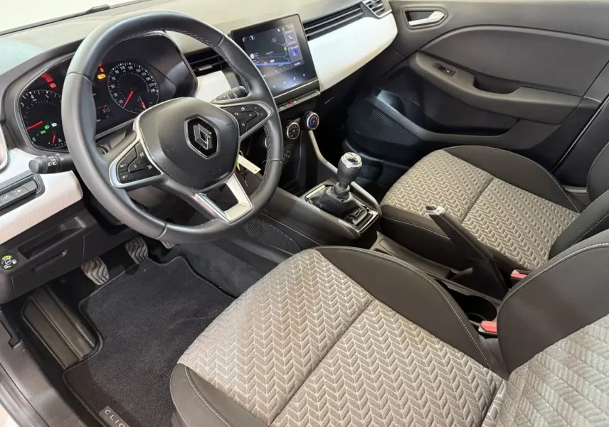 Intérieur avant droit de la Renault Clio Business TCe 100 GPL 2023, volant cuir, sièges tissu gris et console centrale manuelle.