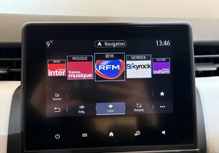 Écran tactile central de la Renault Clio Business blanc, affichant les stations radio avec interface moderne.