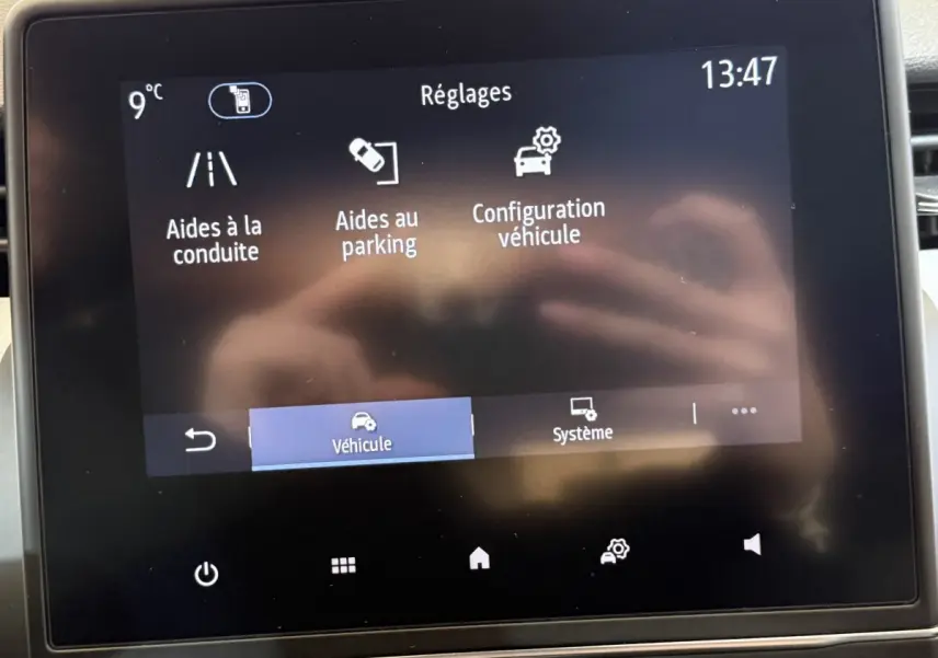 Écran tactile central de la Renault Clio Business blanc montrant le menu des réglages aides à la conduite et parking.