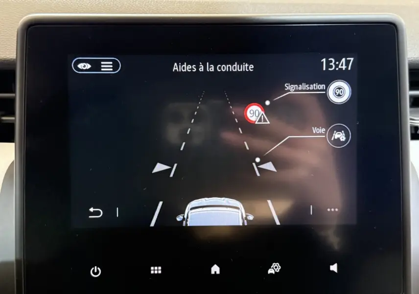 Écran tactile intérieur de la Renault Clio Business 2023 affichant les aides à la conduite et la signalisation routière.