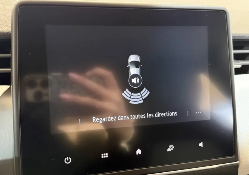 Écran tactile central de la Renault Clio Business blanc, affichant l'alerte de détection autour du véhicule.