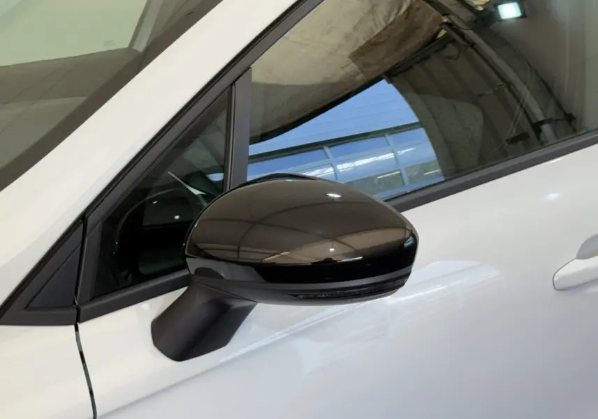 Rétroviseur noir côté conducteur sur Renault Clio Business blanc, vue rapprochée du côté gauche avant.