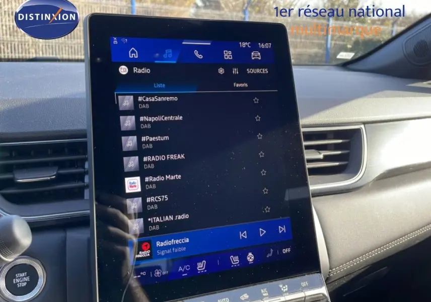 Vue intérieure du tableau de bord de la Renault Symbioz gris cassiopée, avec écran tactile central affichant les radios DAB.
