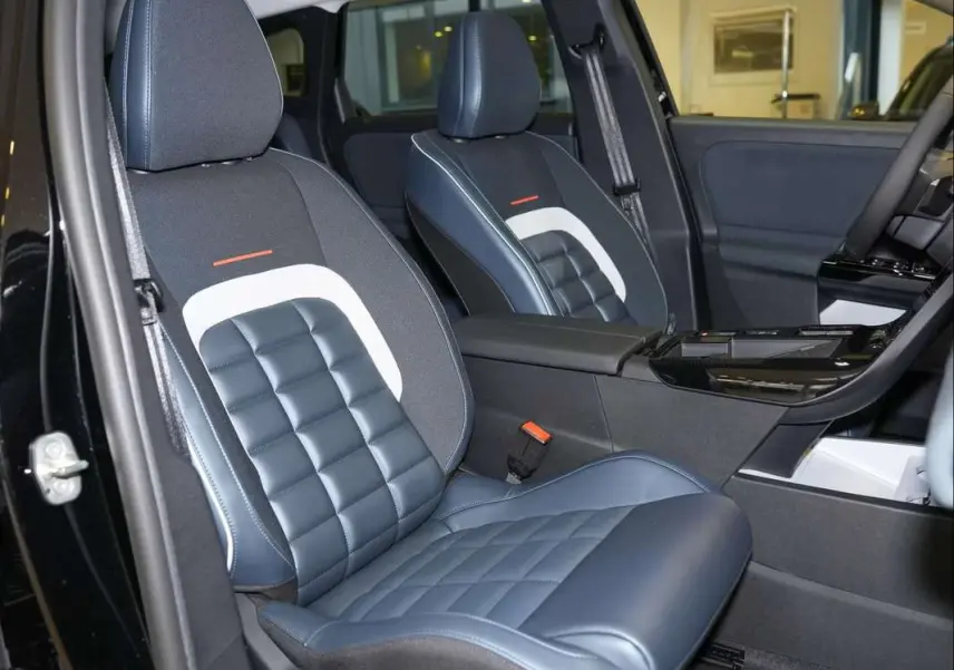 Vue intérieure côté avant gauche du Citroën C5 Aircross New Hybrid 2026, sièges bi-matière bleu et noir avec surpiqûres.