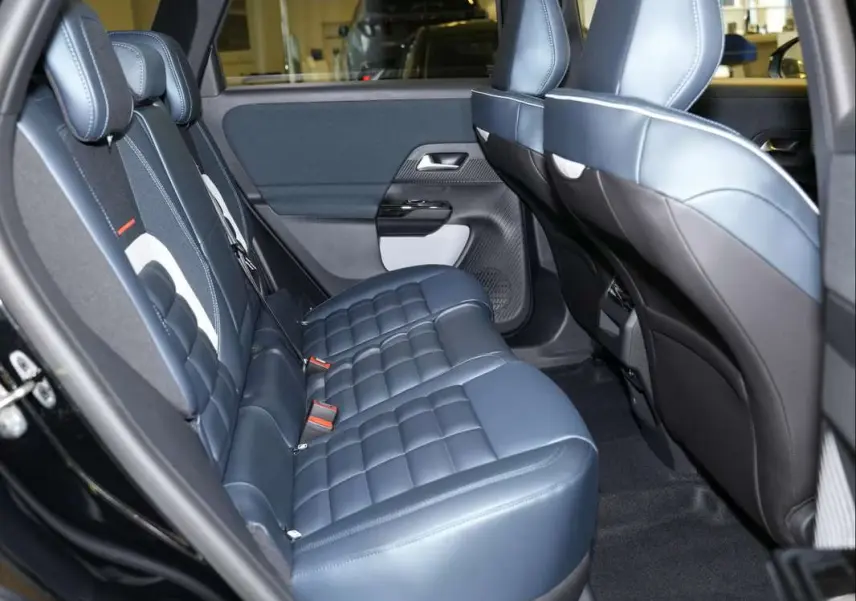 Vue intérieure arrière côté gauche du Citroën C5 Aircross 2026, sièges cuir bleu matelassé avec surpiqûres blanches.