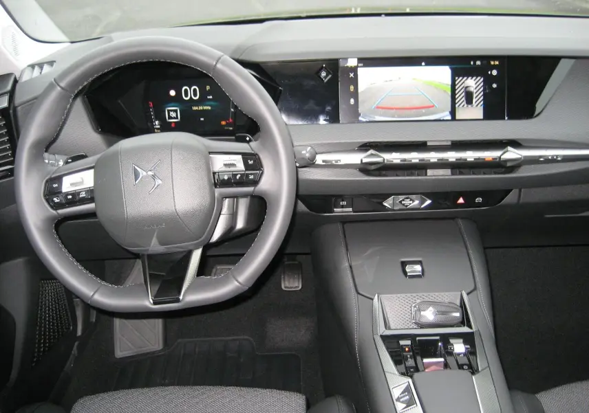 Vue intérieure du tableau de bord et volant du DS4 2024 avec écran central affichant la caméra de recul.