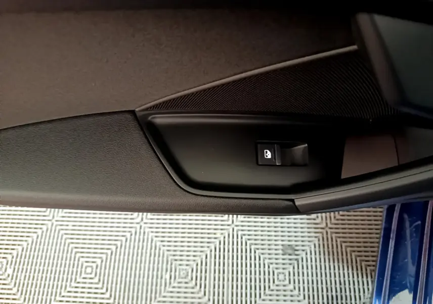 Détail de la commande de verrouillage sur la porte côté gauche d'une Audi A3 bleu 2023.