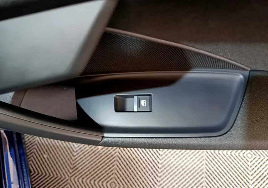 Gros plan sur le bouton de verrouillage de porte côté conducteur d'une Audi A3 bleu 2023, intérieur noir.