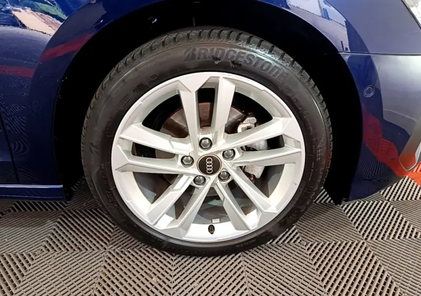 Gros plan sur la roue avant droite de l'Audi A3 bleu 35 TFSI 150 MHEV avec jante argentée et pneu Bridgestone.
