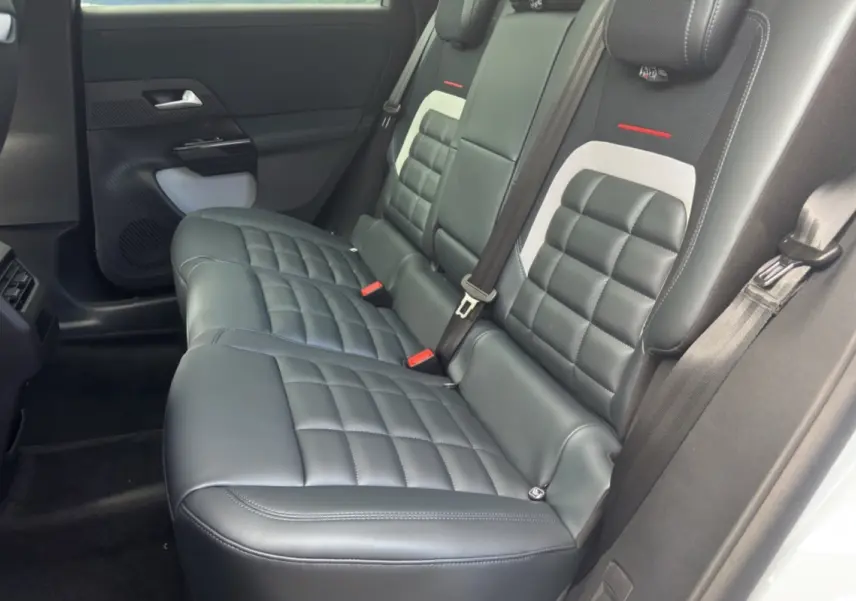 Vue latérale de la banquette arrière cuir noir matelassé avec ceintures et détails gris du Citroën C5 Aircross 2026.