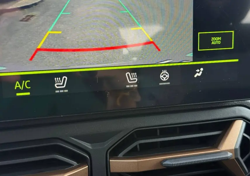 Détail de l’écran tactile avec caméra de recul et aérateurs noirs et bronze du tableau de bord du Dacia Duster gris.