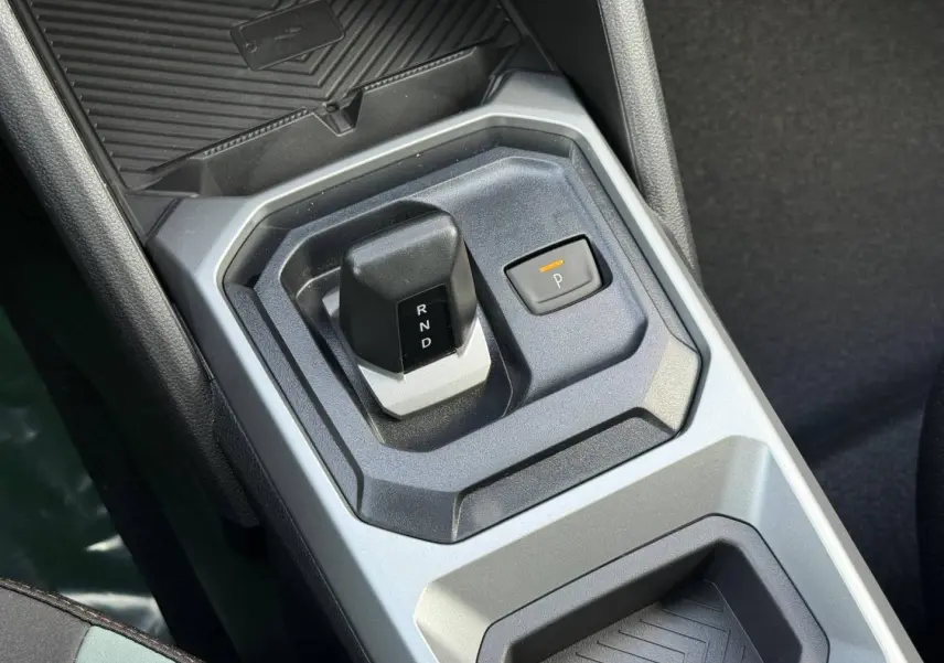 Gros plan sur la commande de boîte automatique grise du Dacia Duster 2026, avec levier compact et bouton de parking.