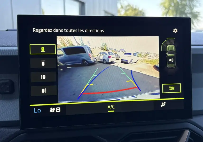 Écran tactile intérieur montrant la caméra multivues du Dacia Duster blanc Glacier en vue arrière pour le stationnement.