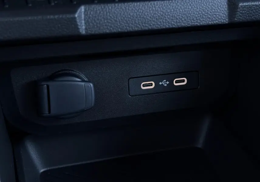 Gros plan sur deux prises USB type C et une prise 12V noires dans la console centrale du Dacia Duster Blanc Glacier.