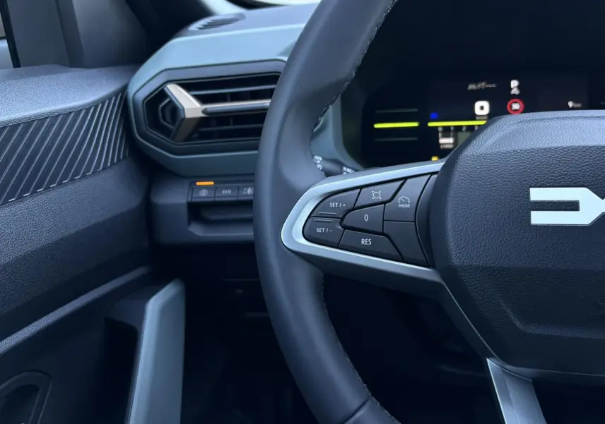 Gros plan sur le volant côté gauche et la partie gauche du tableau de bord du Dacia Duster 2026, intérieur noir.
