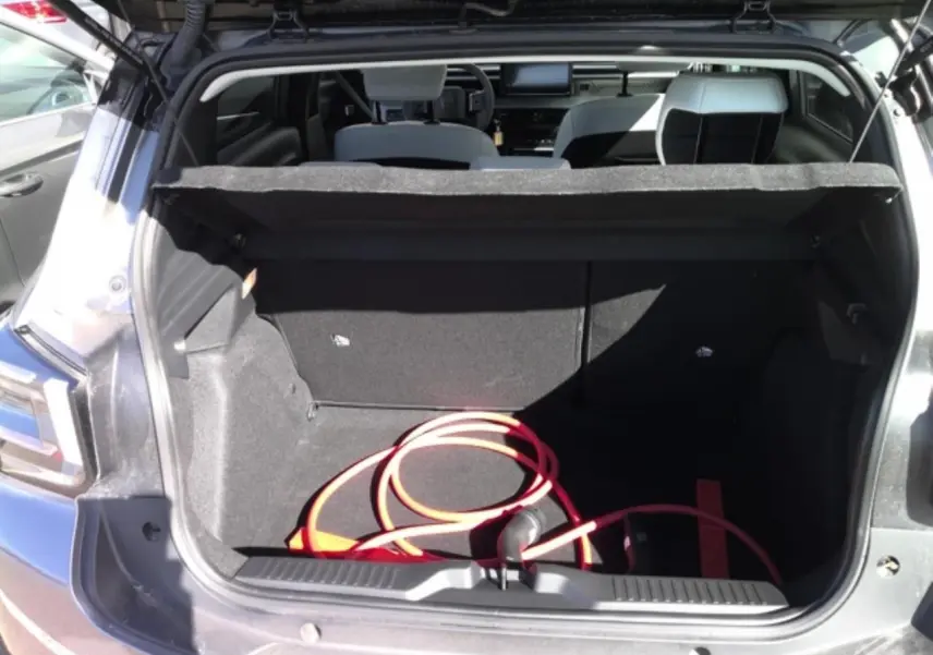 Coffre ouvert d’une Citroën C3 ë-113 Berline Max gris Artense 2025, avec câble de recharge électrique visible à l’intérieur.