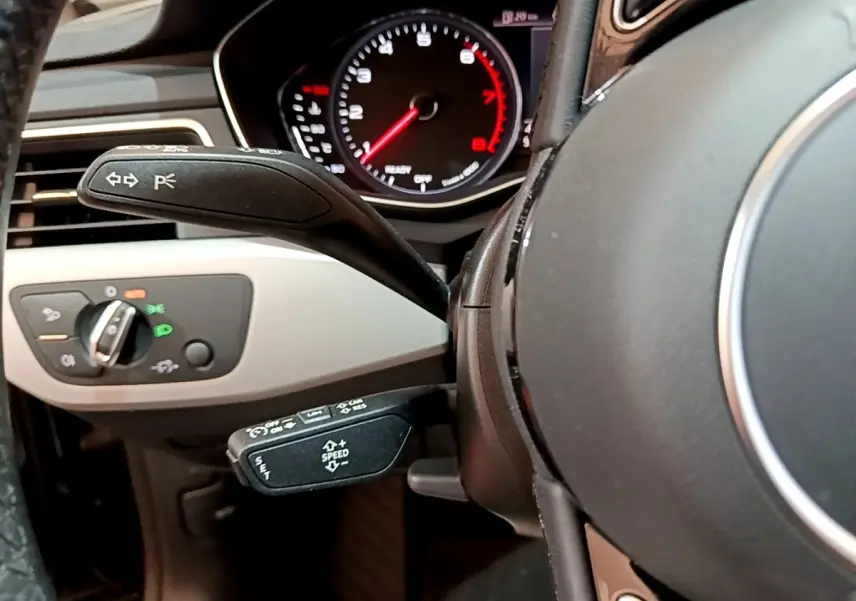 Gros plan sur le volant noir et le tableau de bord avec compte-tours rouge d'une Audi A5 35 TFSI 2021.