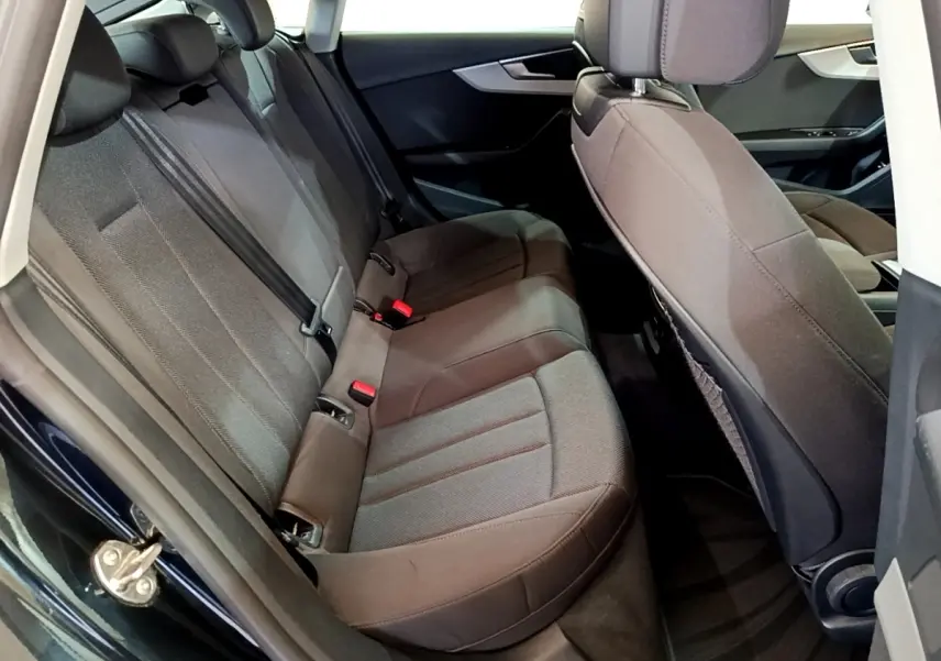 Vue intérieure côté arrière gauche montrant la banquette arrière en tissu gris de l'Audi A5 noir 2021.