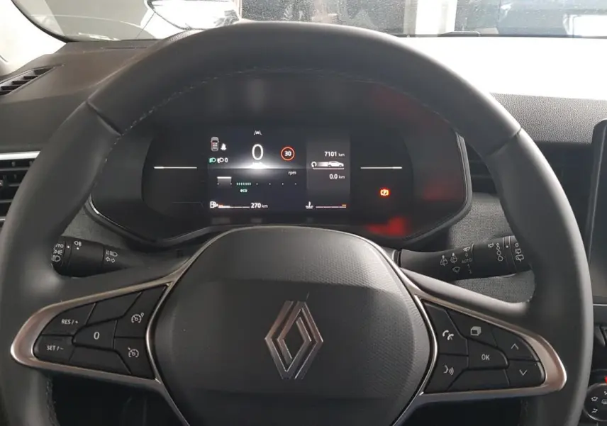 Vue intérieure centrée sur le volant noir de la Renault Clio V Blue dCi 2025 avec tableau de bord digital et écran tactile.