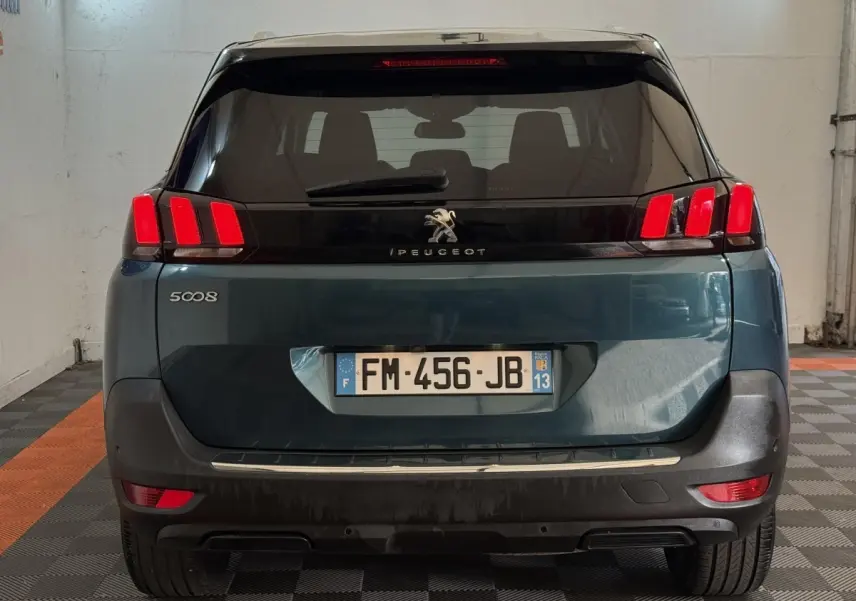 Vue arrière d’un Peugeot 5008 bleu avec feux arrière à trois griffes rouges et plaque d’immatriculation française.