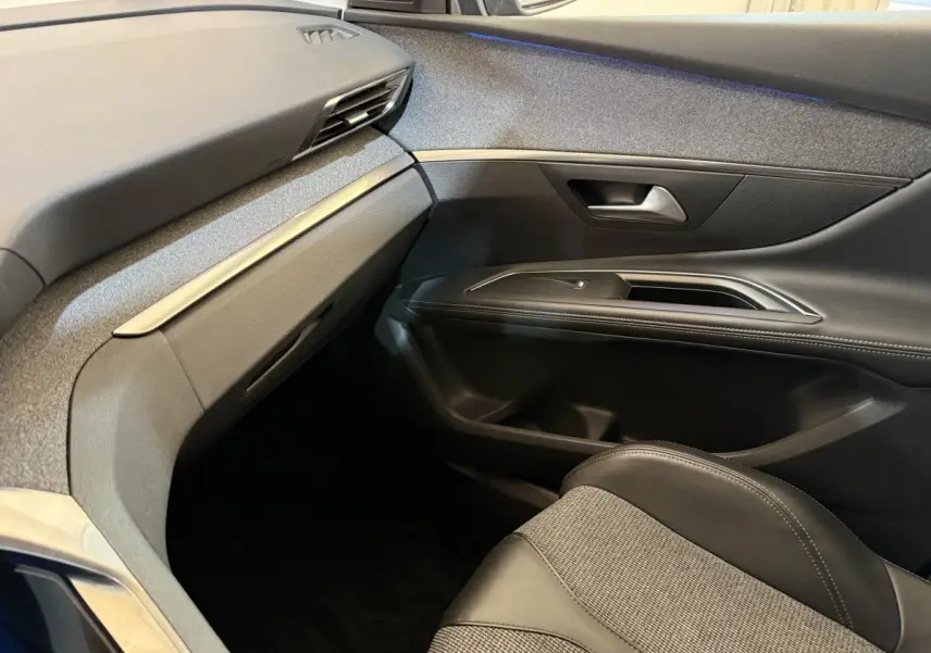 Vue intérieure côté passager avant du Peugeot 5008 2019, avec sellerie cuir noire et tableau de bord gris foncé.