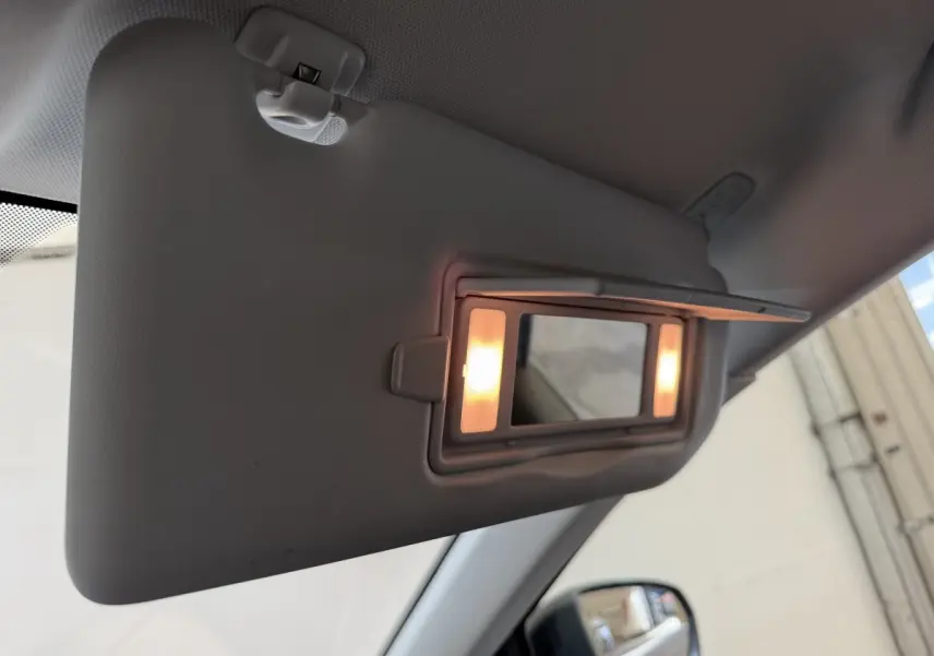 Détail du pare-soleil côté conducteur avec miroir éclairé dans l’habitacle d’un Peugeot 5008 bleu.