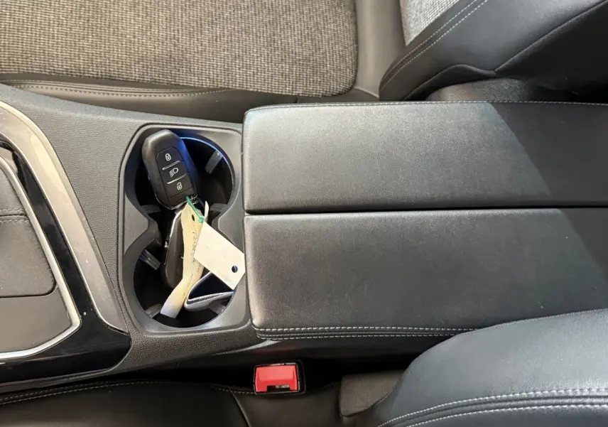 Gros plan sur la console centrale noire avec porte-gobelets contenant la clé de la Peugeot 5008 Puretech 130 S&S Allure.