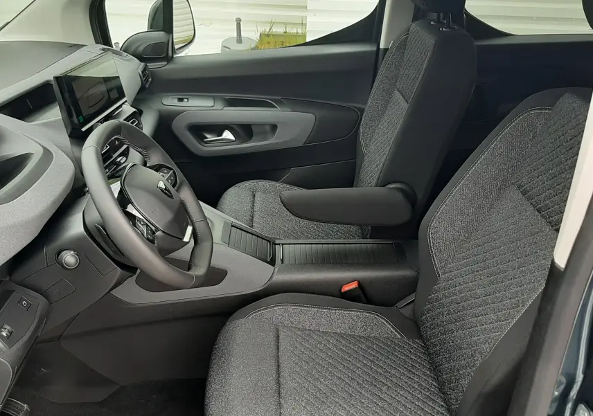 Vue intérieure côté conducteur du Peugeot Rifter Bleu Kiama 2026, montrant les sièges tissu gris et le tableau de bord moderne.